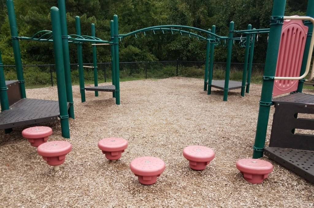 playground with landscaping mulch green bars and red stepping stones